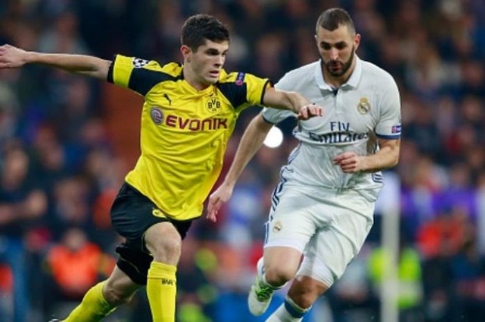 Gelandang Borussia Dortmund, Christian Pulisic (kiri), berduel dengan Karim Benzema (Real Madrid) dalam partai Liga Champions di Santiago Bernabeu pada 7 Desember 2016.