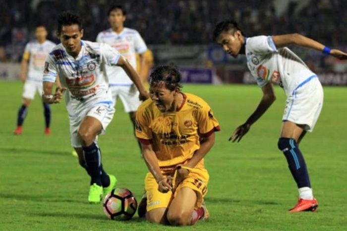 Gelandang Sriwijaya FC Adam Alis kesakitan setelah dilanggar pemain Arema FC dalam laga babak 8 besar Piala Presiden di Stadion Manahan, Solo.