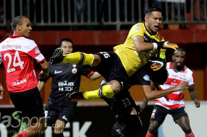 Andritany Ardhiyasa (Persija) sedang berjibaku menjaga gawangnya sambil diamati Peter Odemwingie (Madura United).