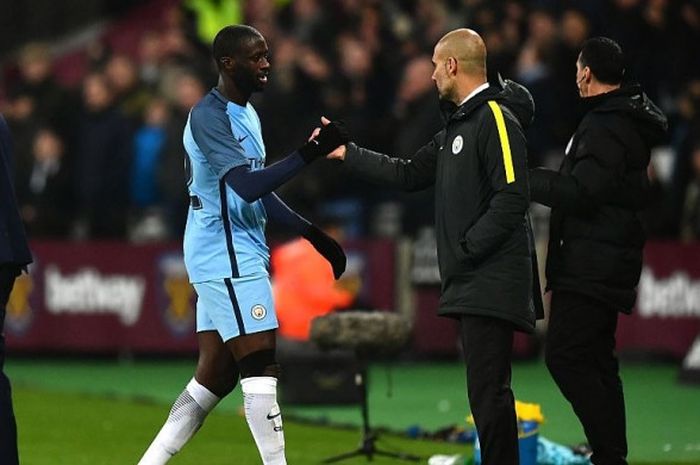 Manajer Manchester City, Josep Guardiola, bersalaman dengan Yaya Toure dalam laga ronde ketiga Piala FA kontra West Ham United di Stadion London, Inggris, pada 6 Januari 2017.