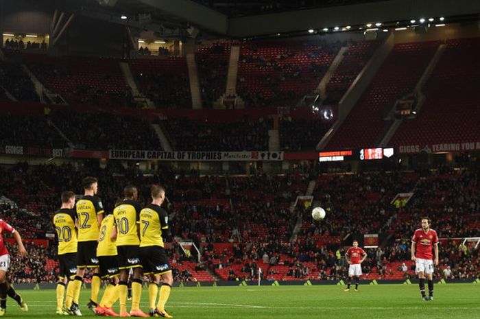 Aksi striker Manchester United, Anthony Martial (kanan), saat mengeksekusi tendangan bebas dalam laga ronde ketiga Piala Liga Inggris 2017-2018 menghadapi Burton Albion dengan latar belakang penampakan tribune kosong Stadion Old Trafford, Manchester, Inggris, pada Rabu (20/9/2017).