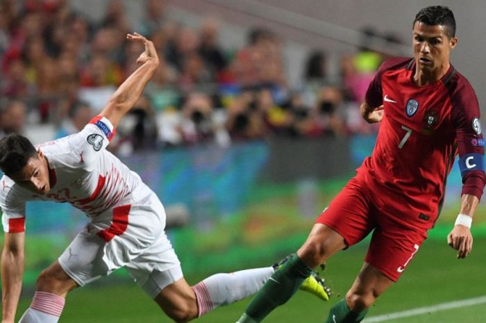 Kapten Portugal, Cristiano Ronaldo (kanan), berduel dengan pemain Swiss, Fabian Schar, dalam laga Grup B Kualifikasi Piala Dunia 2018 zona Eropa di Stadion da Luz, Lisbon, pada 10 Oktober 2017.