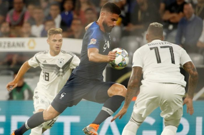 Penyerang Prancis, Olivier Giroud (tengah), mendapat penjagaan dari pemain Jerman, Joshua Kimmich (kiri) dan Jerome Boateng, dalam laga UEFA Nations League di Stadion Allianz Arena, Muenchen, Jerman pada 6 September 2018.