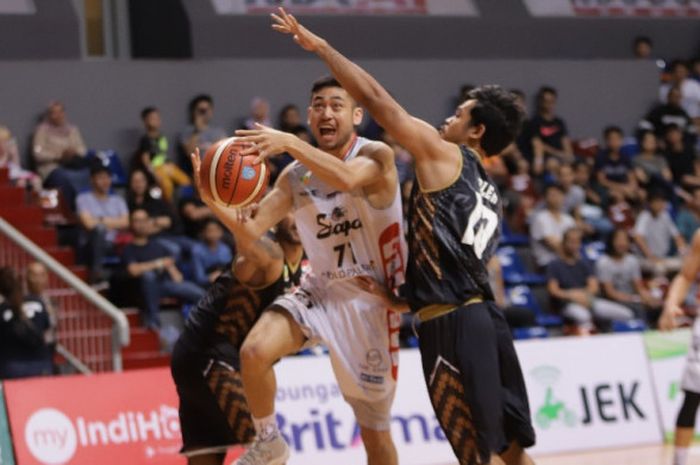 Pemain Stapac Jakarta, Handri Satrya Santosa, berupaya melewati penjagaan pemain-pemain Bank BPD DIY Bima Perkasa Jogja pada laga pembuka Seri IV IBL 2017-2018 di BritAma Arena, Jakarta, Kamis (4/1/2017).