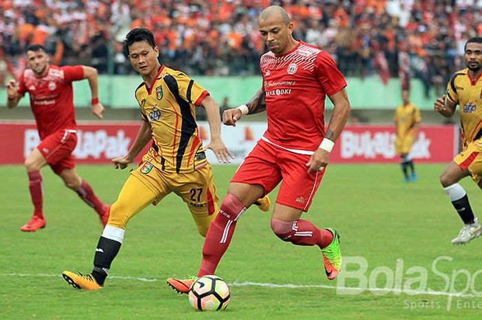 Aksi Striker Persija Jakarta, Ivan Carlos, saat menggiring bola dibayangi bek Mitra Kukar, Dedi Gusmawan pada babak delapan besar Piala Presiden 2018 di Stadion Manahan, Solo, Minggu (4/2/2018).