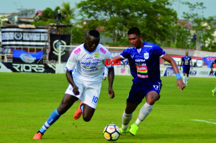  Striker Persib Bandung, Ezechiel Ndouassel dihadang pemain belakang PSIS Semarang di Stadion Moch Soebroto Magelang, Minggu (18/11/2018). 