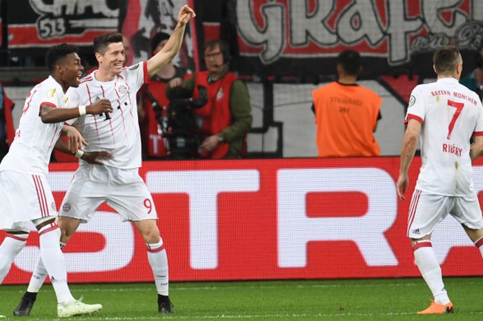 Striker Bayern Muenchen, Robert Lewandowski (tengah), merayakan golnya bersama David Alaba (kiri) dan Franck Ribery dalam laga semifinal Piala Jerman kontra Bayer Leverkusen di Stadion BayArena, Leverkusen, Jerman pada 17 April 2018.