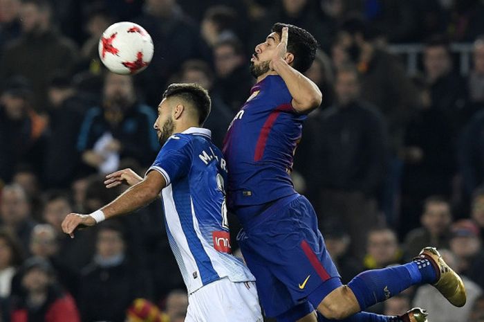 Striker FC Barcelona, Luis Suarez (kanan), berduel dengan bek Espanyol, Marc Navarro, dalam laga leg kedua perempat final Copa del Rey di Stadion Camp Nou, Barcelona, pada 25 Januari 2018.