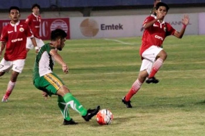 Pemain Mitra Kukar, Dzikri Akbar mencoba melakukan tendangan dan pilar Persija, Al Al Achya siap men