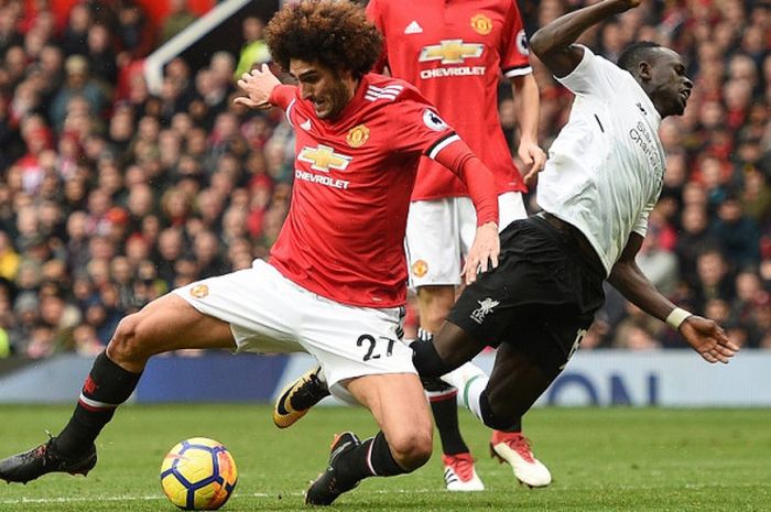 Gelandang jangkar Manchester United, Marouane Fellaini, merebut bola dari winger Liverpool, Sadio Mane, saat kedua tim bertarung di Stadion Old Trafford, Sabtu (10/3/2018).