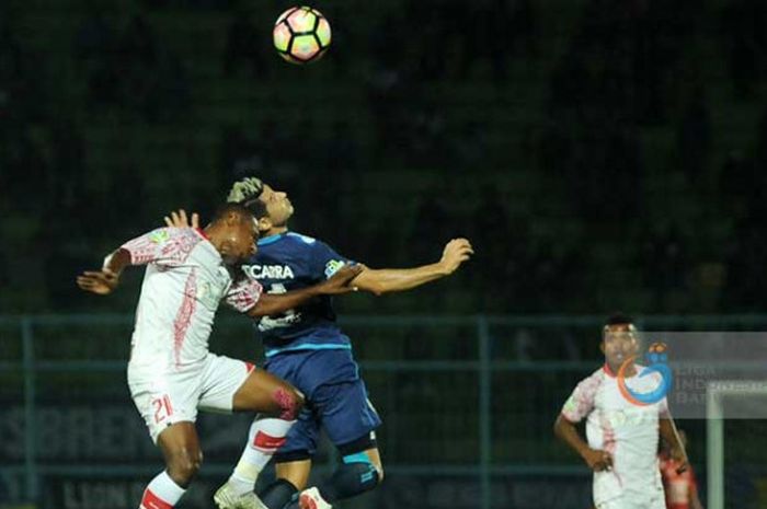 Esteban Vizcarra saat berebut bola dengan Tinus Pae.