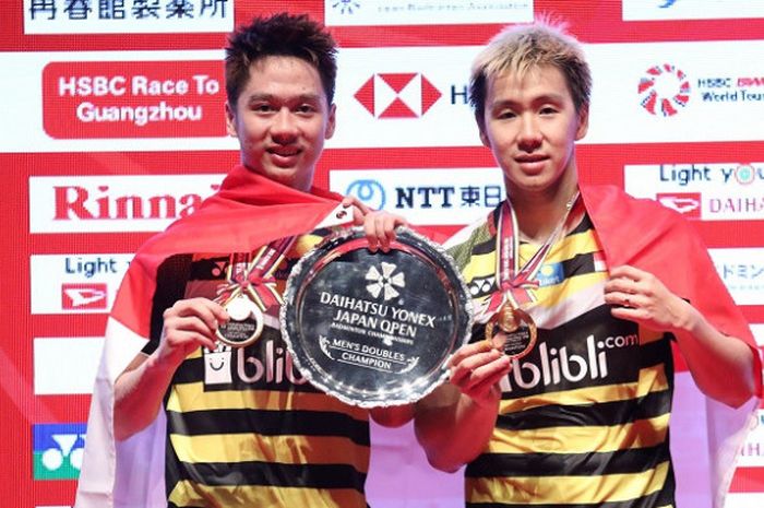 Pasangan ganda putra Indonesia, Marcus Fernaldi Gideon/Kevin Sanjaya Sukamuljo, berpose dengan trofi yang didapat sebagai juara Japan Open 2018 setelah menang atas Li Junhui/Liu Yuchen (China) pada babak final yang berlangsung di Musashino Forest Sport Plaza, Tokyo, Jepang, Minggu (16/9/2018). 