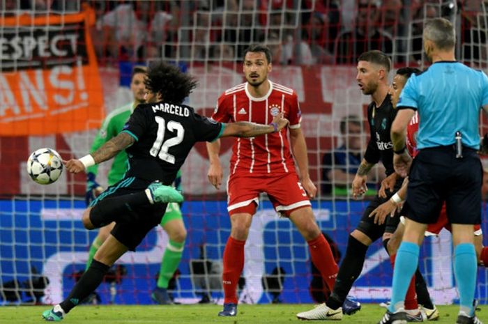    Bek sayap Real Madrid, Marcelo, melepaskan tembakan keras yang berujung gol ke gawang Bayern Muenchen pada laga leg pertama semifinal Liga Champions di Allianz Arena, Rabu (25/4/2018) waktu setempat.   