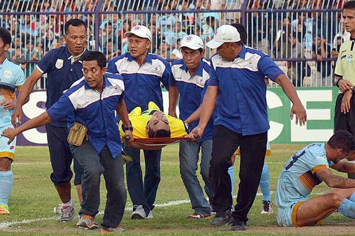 Kiper Persela Lamongan, Choirul Huda, ditandu keluar lapangan setelah tidak sadarkan diri akibat bertabrakan dengan bek Ramon Rodrigues saat melawan Semen Padang dalam laga lanjutan Liga 1 di Stadion Surajaya, Lamongan, Minggu (15/10/2017).