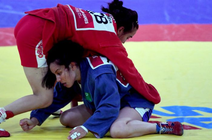 Atlet sambo Uzbekistan Madina Turgunbaeva (atas) melakukan kuncian kepada atlet sambo Tajikistan Ayna Zaripova (bawah) saat bertanding pada babak 16 besar putri -48kg Asian Games 2018 di Assembly Hall JCC Senayan, Jakarta, Jumat (31/8).