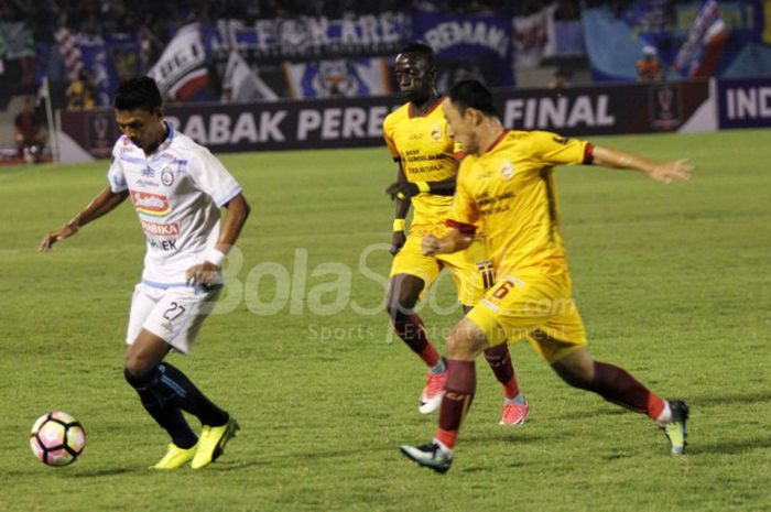 Penyerang Arema FC, Dedik Setiawan menghindari kejaran dua pemain Sriwijaya FC, Makan Konate dan Yu Hyun Koo, pada laga  perempat final Piala Presiden, Minggu (4/2/2018). 