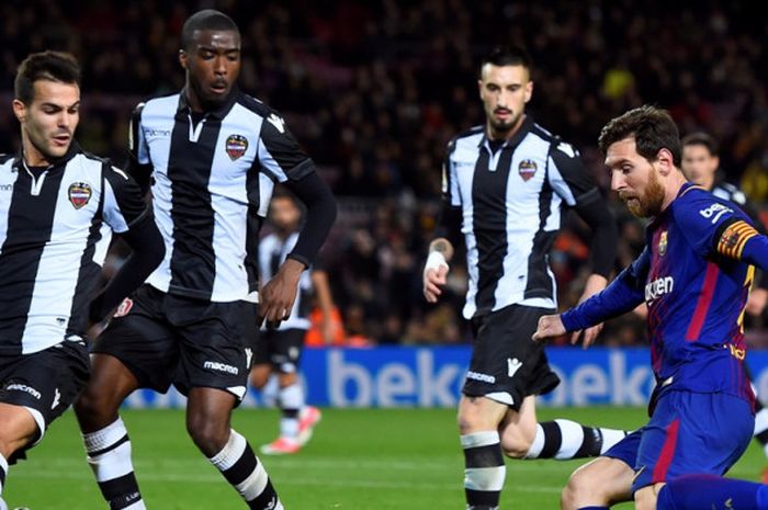 Megabintang FC Barcelona, Lionel Messi (kanan), mendapat pengawalan ketat dari para pemain Levante dalam laga Liga Spanyol di Stadion Camp Nou, Barcelona, pada 7 Januari 2018.