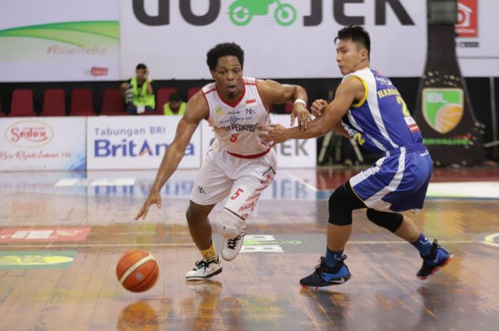 Pemain asing Bank BPD DIY Bima Perkasa Jogja, Antony McDonald (jersey putih), berupaya melewati pemain Satria Muda Pertamina Jakarta, Hardianus Lakudu, pada Seri VIII IBL 2017-2018 di GOR Bima Sakti, Malang, Jawa Timur, Minggu (25/2/2018).