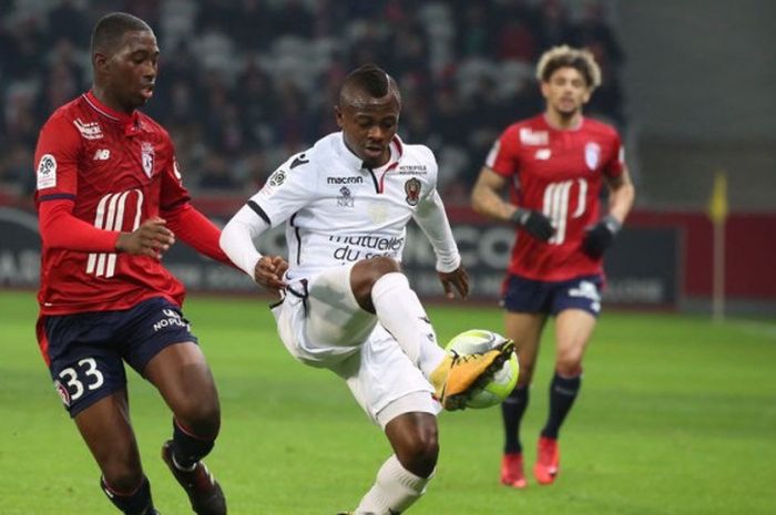 Pemain OGC Nice, Jean Michael Seri (Kanan), melakukan perlawanan dalam laga Liga Prancis melawan Lille OSN, Rabu (20/12/2017) di Stadion Pierre-Mauroy, Lille, Prancis.