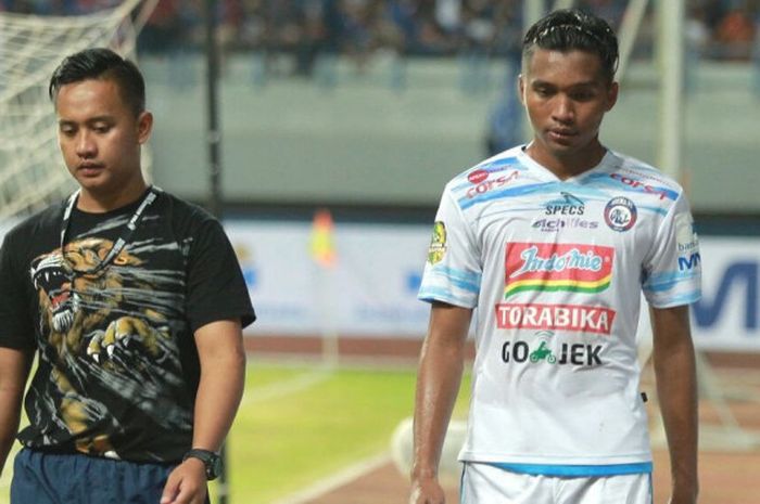 Bek Arema FC, Muhammad Zaenuri (kanan) bersama salah satu tim medis keluar lapangan karena cedera pada laga kontra PSIS Semarang untuk fase penyisihan Grup A Piala Gubernur Kaltim 2018 di Stadion Palaran, Samarinda pada Jumat (23/2/2018) malam. 