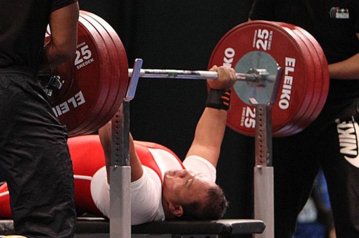 Lifter difabel Indonesia, Anto Boi, saat mengangkat beban pada kelas 88 kg putra ASEAN Para Games 2017. Anto meraih medali emas setelah mengangkat beban 180 kg.