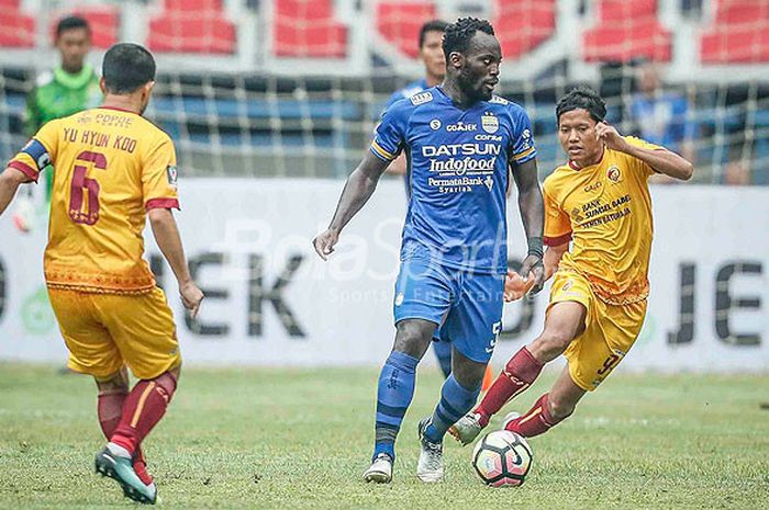      Pemain bintang Persib Bandung, Michael Essien (tengah), mendapat pengawalan ketat dari pemain Sriwijaya FC, Yu Hyun-goo (kiri) dan Adam Alis,  dalam laga pembuka Piala Presiden 2018 di Stadion Gelora Bandung Lautan Api, Kab. Bandung, Selasa (16/1/2018).     