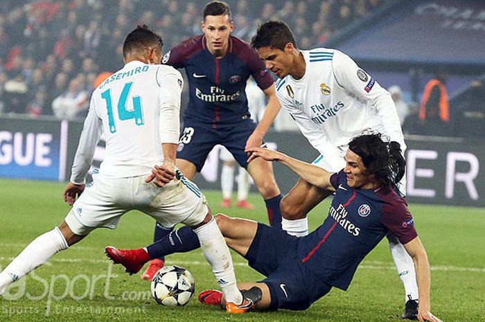 Pemain Real Madrid, Casemiro (kiri) dan Marco Asensio (kanan), berupaya merebut bola dari penguasaan striker Paris Saint-Germain, Edinson Cavani, dalam laga leg kedua 16 besar Liga Champions 2017-2018 di Parc des Princes, Rabu (7/3) dini hari WIB.