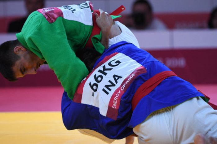 Pertarungan atlet kurash Indonesia Aprilianda Adi Timur (bawah) menahan serangan atlet kurash Uzbekistan Maruf Gaybulloev (atas) saat bertanding pada babak 32 besar putra -66kg Asian Games 2018 di Assembly Hall JCC Senayan, Jakarta, Selasa (28/8). 