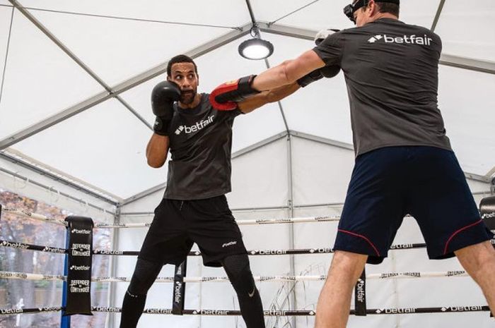 Mantan bek tim Manchester United, Rio Ferdinand, berlatih tinju di ring.