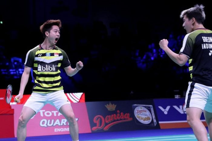 Pasangan ganda putra Indonesia, Marcus Fernaldi Gideon/Kevin Sanjaya Sukamuljo, bereaksi setelah memastikan gelar Denmark Open 2018 di Odense Sports Park, Minggu (21/10/2018).