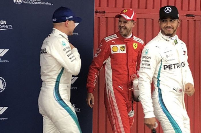 Sebastian Vettel (tengah) berbincang dengan pebalap Mercedes, Valtteri Bottas (kiri) sesaat usai sesi kualifikasi F1 GP Spanyol 2018, Sabtu (12/5/2018).