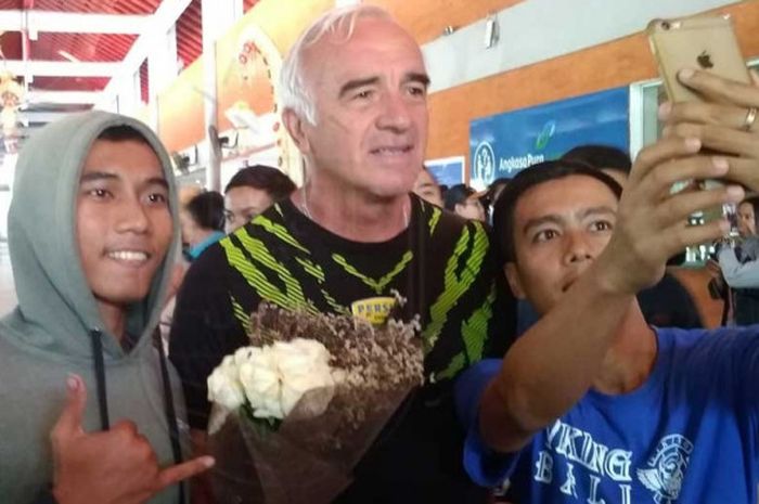 Pelatih Persib Bandung Mario Gomez (tengah) disambut dan diajak berswafoto oleh bobotoh ketika tiba di Bandara Internasional I Gusti Ngurah Rai, Denpasar, Bali, Selasa (16/10/2018) sore.