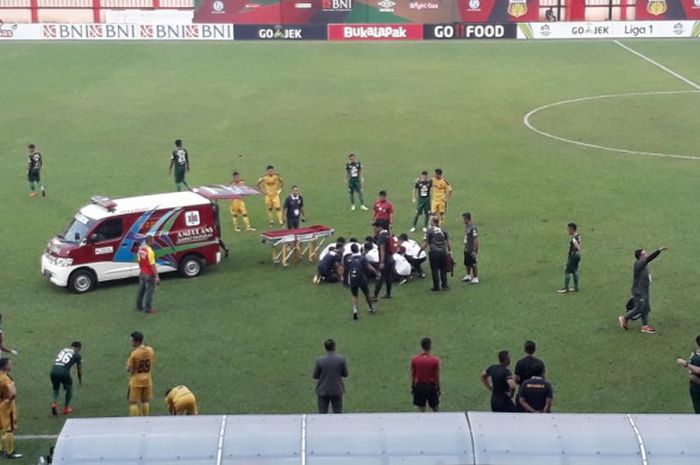 Mobil ambulans dan petugas medis menangani bek Andri Muladi yang mengalami salah jatuh saat timnya, Persebaya dijamu Bhayangkara FC pada laga pekan ke-15 Liga 1 2018 di Stadion PTIK, Jakarta Selatan, 11 Juli 2018. 