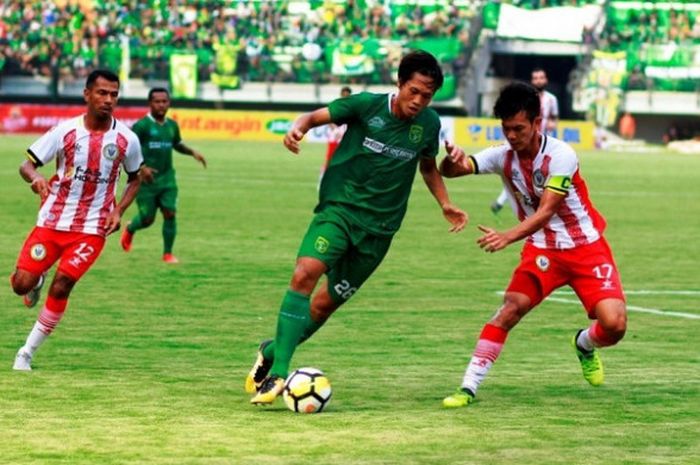 Penyerang Persebaya, Rishadi Fauzi mencoba melewati kapten Sarawak FA, Hairol Mokhtar (kanan) pada laga uji coba di Gelora Bung Tomo, Surabaya, Minggu (18/3/2018) sore. 