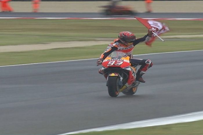 Marc Marquez berselebrasi dengan membawa bendera usai memenangi ajang MotoGP seri San Marino (10/9/2017).