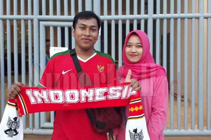 Suporter Timnas U-19 Indonesia Muhadi bersama tunangannya Rini datang dari Lampung demi menyaksikan penampilan Egy Maulana dkk melawan Thailand di Stadion Wibawa Mukti, Minggu (8/10/2017).