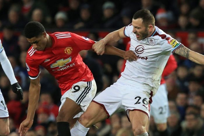 Striker Manchester United, Marcus Rashford (tengah), berduel dengan bek Burnley, Phil Bardsley (kanan), dalam laga Liga Inggris di Stadion Old Trafford, Manchester, pada 26 Desember 2017.