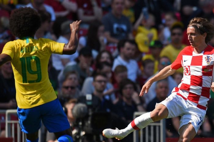 Gelandang Kroasia, Luka Modric (kanan), berduel dengan pemain Brasil, Willian, dalam laga persahabatan di Stadion Anfield, Liverpool, Inggris pada 3 Juni 2018.