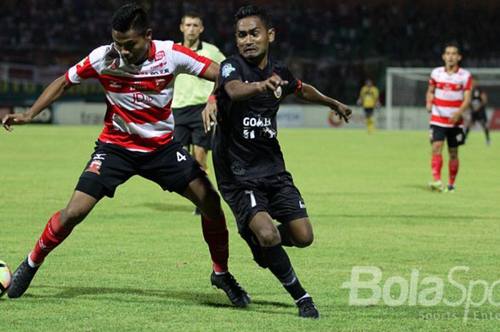 Asep Berlian (kiri) saat merebut bola dari Ramdani Lestaluhu di pertandingan Gojek Traveloka Liga 1 pekan 21 Madura United melawan Persija Jakarta yang berakhir dengan skor akhir 1-1 di Stadion Gelora Ratu Pamellingan Pamekasan, Jawa Timur (21/08/2017).