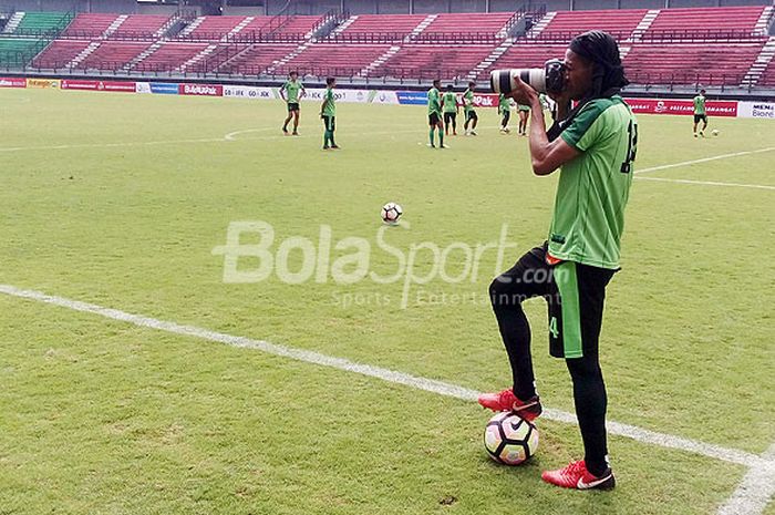  Bek Persebaya, Ruben Sanadi, mengabadikan aksi rekan setimnya dengan kamera pinjaman dari seorang jurnalis disela-sela jeda latihan di Gelora Bung Tomo Surabaya, Rabu (4/42018). 