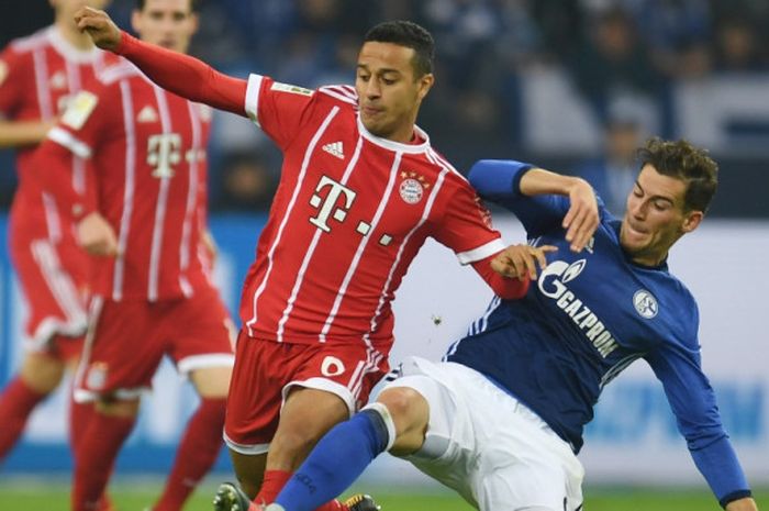 Gelandang Schalke, Leon Goretzka (kanan), berduel dengan pemain Bayern Muenchen, Thiago Alcantara, dalam laga Liga Jerman di Gelsenkirchen, Jerman, pada 19 September 2017. 