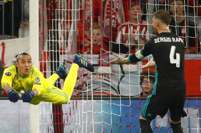 Kiper Real Madrid, Keylor Navas (kiri), melompat untuk menghalau bola dalam laga leg pertama semifinal Liga Champions kontra Bayern Muenchen di Stadion Allianz Arena, Muenchen, Jerman pada 25 April 2018.   