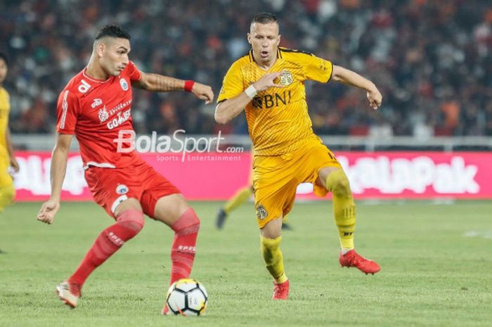 Penyerang Persija Jakarta, Addison Alves, berduel dengan pemain Bhayangkara FC, Nikola Komazec, pada laga pembuka Liga 1 2018 di Stadion Utama GBK pada Jumat (23/3/2018).