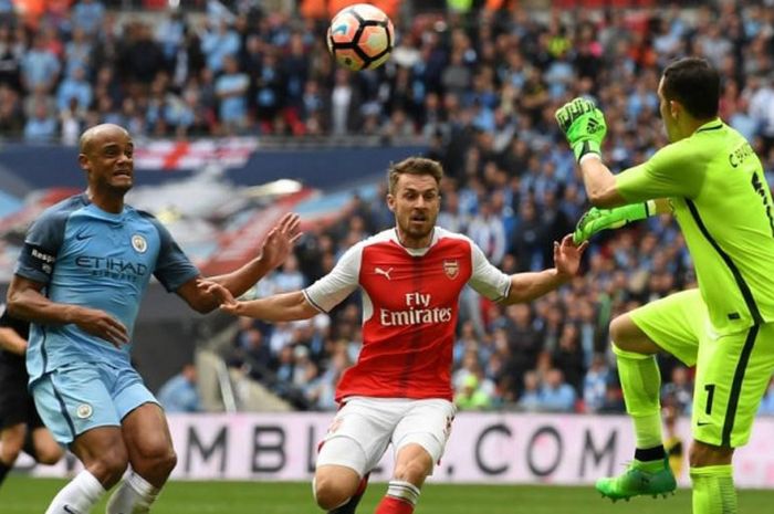 Bek Manchester City, Vincent Kompany (kiri), mengejar gelandang Arsenal, Aaron Ramsey, untuk memerebutkan bola dalam partai semifinal Piala FA di Wemblesy Stadium, London, 23 April 2017.