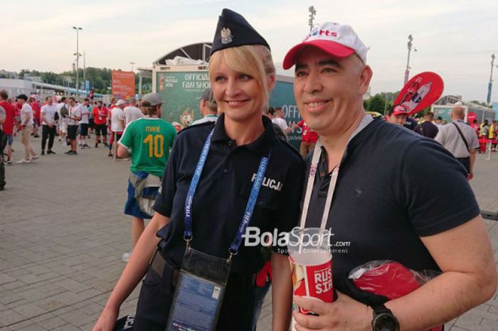 Seorang polisi Polandia berfoto bersama suporter seusai laga Polandia vs Senegal di Spartak Stadium, Moskow, pada Senin (19/6/2018).