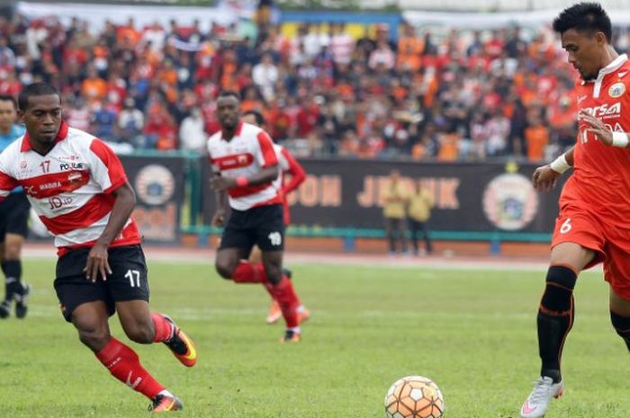 Bek Persija, Maman Abdurahman (kanan) mencoba menjauhkan bola dari pemain Madura United, Elthon Mara