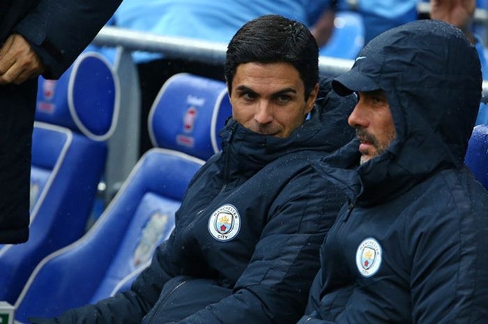 Pelatih Manchester City, Pep Guardiola (kanan), dan sang asisten, Mikel Arteta, berbincang sebelum dimulainya laga Liga Inggris kontra Cardiff City di Stadion Cardiff City, Cardiff, Wales pada 22 September 2018.