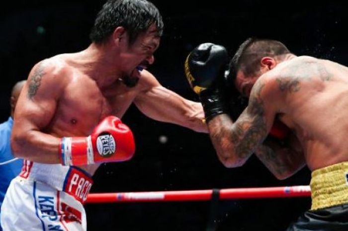 Manny Pacquiao (kiri) saat melesatkan pukulan ke Lucas Matthysse (kanan) pada duel yang digelar di Axiata Arena,  Kuala Lumpur, Malaysia, Minggu (15/7/2018). 