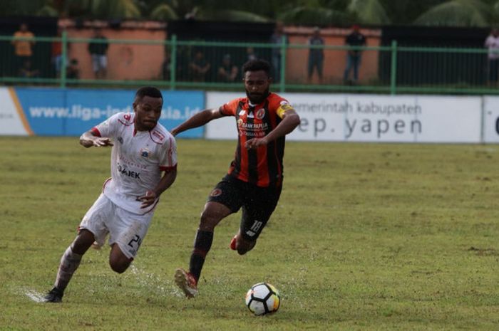 Pemain Persija Jakarta, Yan Pieter Nasadit diadang pemain Perseru Serui, Arthur Bonai di Stadion Mar