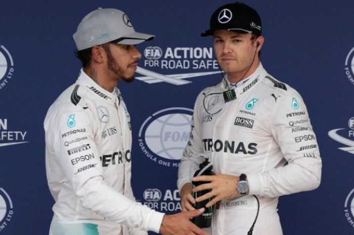 Pebalap Mercedes AMG Petronas F1 Team asal Jerman, Nico Rosberg (kanan), dan rekan satu timnya asal Inggris, Lewis Hamilton, bereaksi setelah menyelesaikan sesi kualifikasi GP Jepang di Sirkuit Suzuka, Sabtu (8/10/2016)